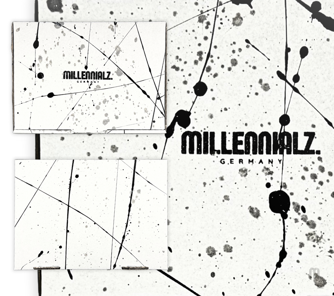 Handveredeltes Verpackungsdesign von Millennialz mit schwarzem und grauem Spritzlack auf weißem Karton. Das abstrakte Muster wurde in individueller Handarbeit aufgebracht; das Logo „Millennialz Germany“ ist mittig auf der Vorderseite platziert. Jede Verpackung ist einzigartig.
