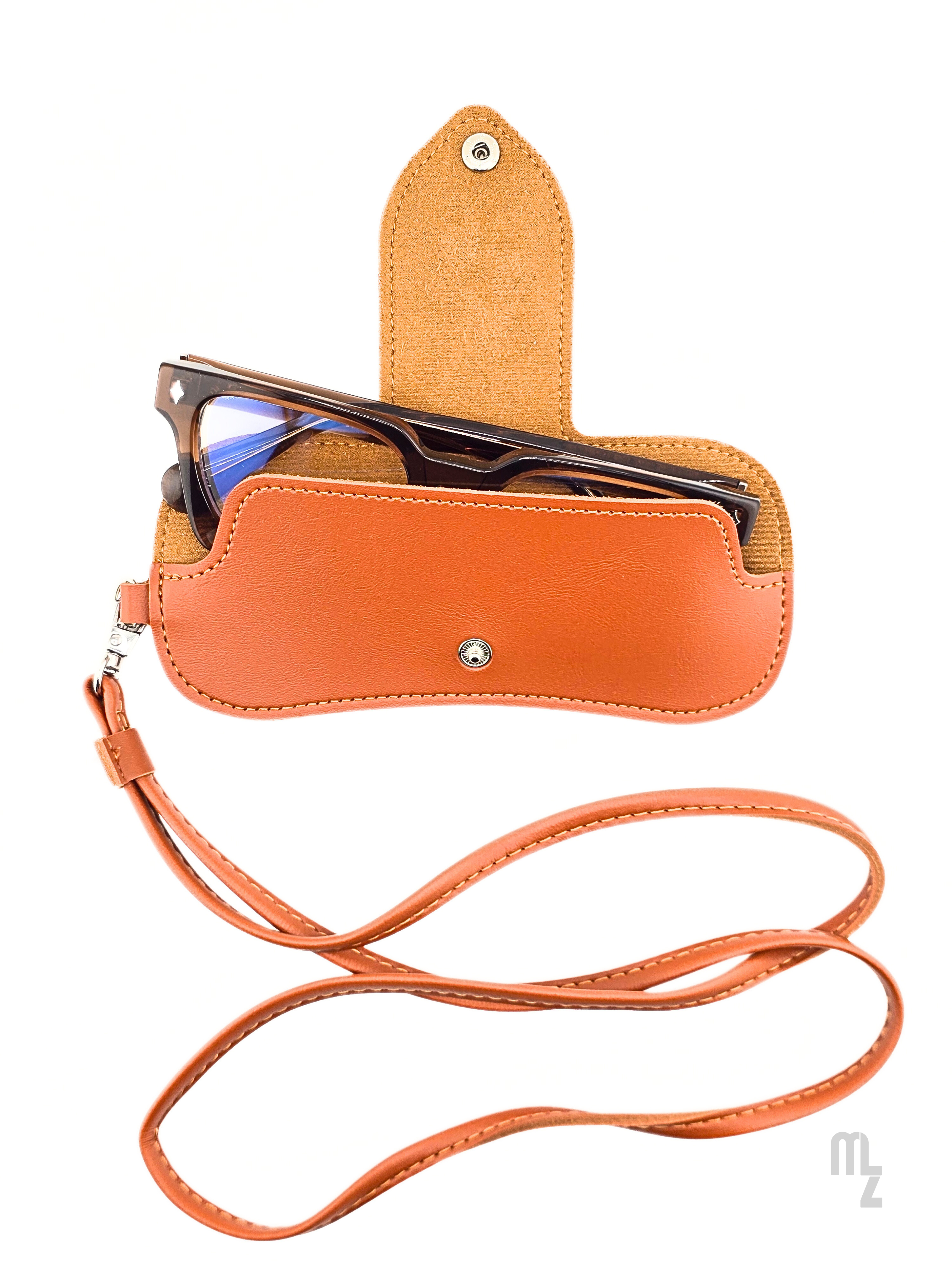 Savona Strap Case – Design-Brillenetui aus cognacfarbenem Kunstleder mit abnehmbarem Riemen.